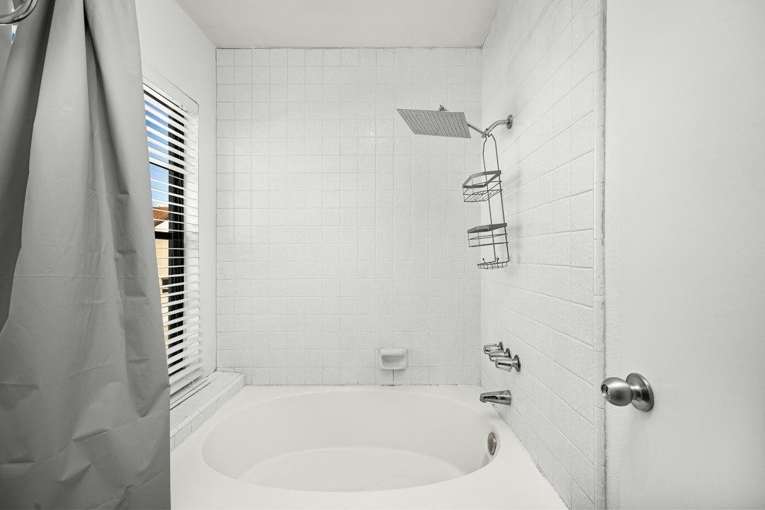white ceramic subway tile tub surround with chrome fixtures