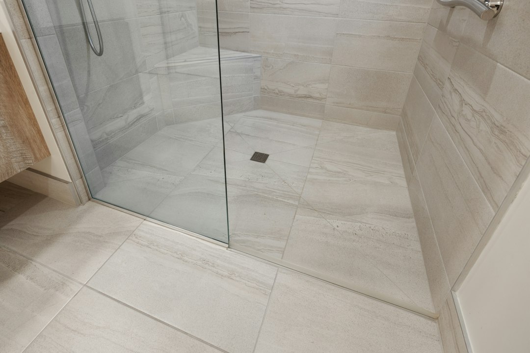 white marble look porcelain shower wall with matching white grout