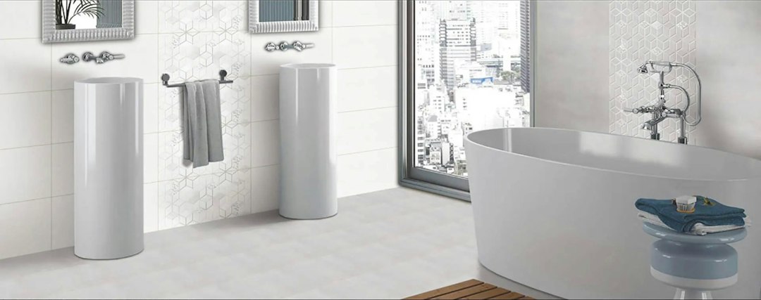 gray matte porcelain floor tile next to white glossy ceramic wall tile in a bathroom