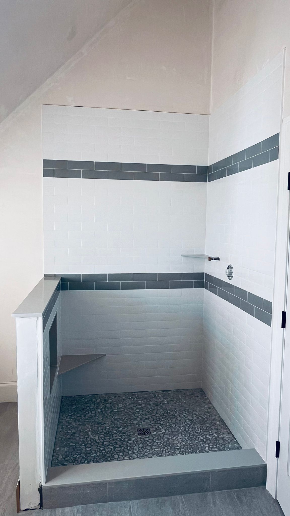 subway tile shower walls with pebble shower floor