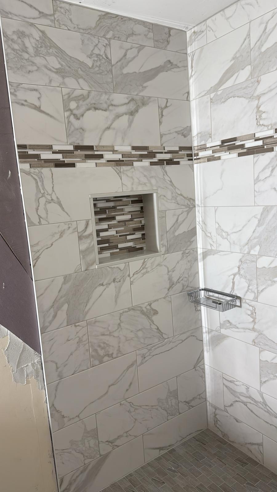 Calacatta marble shower with a recessed niche and stone sill